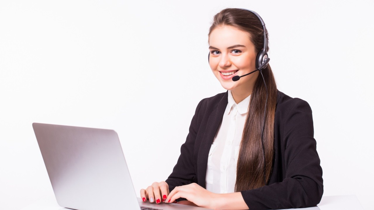 Executive hospitality virtual assistant wearing a headset and working on a laptop