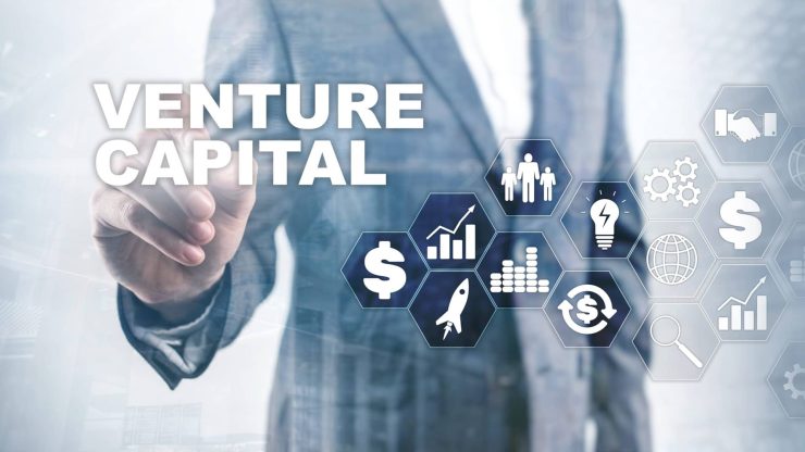 Businessperson in a suit touching hexagon icons for funding, growth, ideas and partnerships next to the words Venture Capital