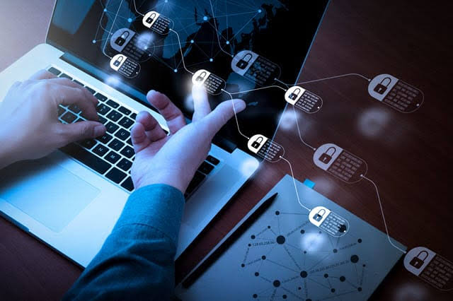 Hands typing on a laptop as a network of padlock icons connects secure files across the screen
