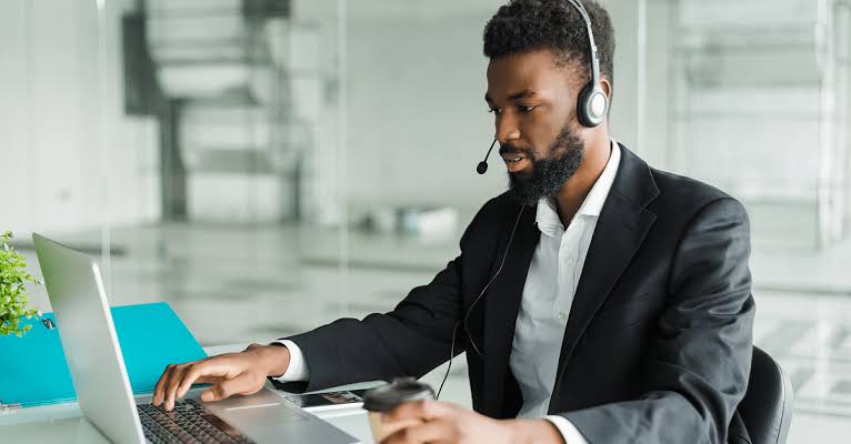 Hospitality virtual assistant on a headset call while working on a laptop